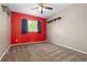 Bedroom featuring a ceiling fan, a window with blue curtains, and a red accent wall at 2043 Fendlebrush St, Highlands Ranch, CO 80129