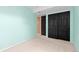 This carpeted bedroom features sliding closet doors, aqua walls, and ample natural light at 2043 Fendlebrush St, Highlands Ranch, CO 80129