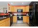 Kitchen with stainless steel appliances, wooden cabinets, granite countertops and a black refrigerator at 2043 Fendlebrush St, Highlands Ranch, CO 80129
