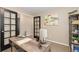 Office space with wood desk, black french doors, bookshelves, neutral decor and modern lamp at 2043 Fendlebrush St, Highlands Ranch, CO 80129