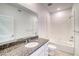 Bathroom vanity featuring a single sink, large mirror, and shower-tub combo at 23950 E 41St Ave, Aurora, CO 80019