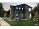 New construction home shows modern exterior with brick and siding, professional landscaping, and a red front door at 23950 E 41St Ave, Aurora, CO 80019