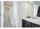 Well-lit bathroom features a modern vanity with sleek fixtures and a doorway to a shower-tub area at 3385 Birch Rd, Longmont, CO 80504