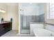 Bathroom featuring a standalone soaking tub and a glass enclosed shower with tiled walls and dual shower heads at 3385 Birch Rd, Longmont, CO 80504