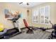 Well-lit exercise room featuring a treadmill, weight bench, rowing machine, and plenty of natural light at 3385 Birch Rd, Longmont, CO 80504