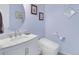 Stylish powder room with a modern toilet, sleek fixtures, a marble countertop, and a round decorative mirror at 3385 Birch Rd, Longmont, CO 80504
