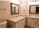 Bathroom featuring dual sinks with framed mirrors, vanity and toilet at 8659 E Kenyon Ave, Denver, CO 80237