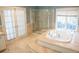 Bright bathroom features a glass shower, soaking tub, and double doors leading to a relaxing retreat at 8659 E Kenyon Ave, Denver, CO 80237