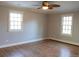 Bright bedroom features hardwood floors, two windows, neutral walls and ceiling fan with light at 8659 E Kenyon Ave, Denver, CO 80237