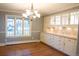 Bright dining room with hardwood floors, chandelier, and built-in cabinets with marble backsplash at 8659 E Kenyon Ave, Denver, CO 80237