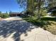 Wide driveway leads to attached garage and home with lush landscaping and mature trees at 8659 E Kenyon Ave, Denver, CO 80237