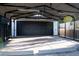 Detached garage with black metal door and concrete parking pad at 8659 E Kenyon Ave, Denver, CO 80237