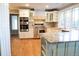 Well-appointed kitchen with stainless appliances, granite countertops, custom cabinets, and access to living spaces at 8659 E Kenyon Ave, Denver, CO 80237