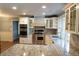 Spacious kitchen boasts stainless appliances, granite countertops, custom cabinetry, and large center island at 8659 E Kenyon Ave, Denver, CO 80237