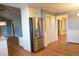 Open kitchen features a stainless steel refrigerator and convenient access to additional rooms at 8659 E Kenyon Ave, Denver, CO 80237