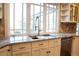 Bright kitchen features white cabinets, granite countertops, stainless appliances, and a large picture window at 8659 E Kenyon Ave, Denver, CO 80237