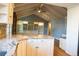 Open-concept kitchen with white cabinets, granite countertops, stainless appliances, and high vaulted ceilings at 8659 E Kenyon Ave, Denver, CO 80237