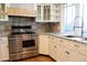 Gourmet kitchen featuring stainless steel appliances, gas range, and white cabinets with granite countertops at 8659 E Kenyon Ave, Denver, CO 80237