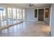 Open living room with travertine flooring, a ceiling fan and glass sliding doors to the back yard at 8659 E Kenyon Ave, Denver, CO 80237