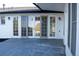 Covered patio with flagstone tile and access to the interior of the home through three glass doors at 8659 E Kenyon Ave, Denver, CO 80237