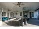 Covered patio with seating, ceiling fans, stone fireplace, and access to outdoor grill at 8659 E Kenyon Ave, Denver, CO 80237