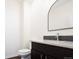 Modern bathroom with dark vanity, granite countertop, and arched mirror at 335 Josephine St # A, Denver, CO 80206