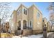 Tan three-story home with a brick walkway and black iron gate at 335 Josephine St # A, Denver, CO 80206
