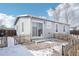 Back of the house featuring grey siding, sliding glass doors, and a gravel area at 262 Apache Pl, Brighton, CO 80603