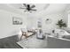 Bright living room with modern decor, tray ceilings, ceiling fan, and hardwood floors at 262 Apache Pl, Brighton, CO 80603