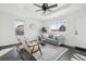 Sun-filled living room features a modern ceiling fan, luxury vinyl plank flooring, and neutral paint at 262 Apache Pl, Brighton, CO 80603