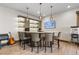 A stylish bar area with seating for six, custom lighting, and a decorative backsplash at 8246 Raphael Ln, Littleton, CO 80125