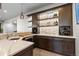 Modern basement bar area with custom cabinetry, wine storage, and a countertop with sink at 8246 Raphael Ln, Littleton, CO 80125