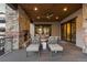 Cozy outdoor living space featuring a stone fireplace, comfortable seating, and panoramic views at 8246 Raphael Ln, Littleton, CO 80125