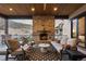 Inviting covered deck with stone fireplace and comfortable seating, perfect for outdoor relaxation and mountain views at 8246 Raphael Ln, Littleton, CO 80125