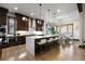 Modern kitchen with dark wood cabinets, large center island, and stainless steel appliances at 8246 Raphael Ln, Littleton, CO 80125
