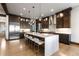 Chef's kitchen boasts dark wood cabinetry, oversized island, and stainless steel appliances at 8246 Raphael Ln, Littleton, CO 80125