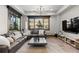 A cozy living room featuring a comfortable sectional sofa, large windows, and natural light at 8246 Raphael Ln, Littleton, CO 80125