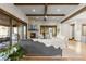 Open-concept living room featuring a stone fireplace, wooden beams, and expansive windows at 8246 Raphael Ln, Littleton, CO 80125