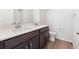 Bright bathroom featuring a double sink, dark cabinets and laminate flooring at 1312 Sienna Peak Cir, Erie, CO 80516