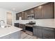 Kitchen view featuring stainless steel appliances, dark cabinetry, quartz countertops and modern finishes at 1312 Sienna Peak Cir, Erie, CO 80516