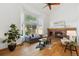 Inviting living room featuring vaulted ceiling, large windows, hardwood flooring and brick fireplace at 5625 W 109Th Cir, Westminster, CO 80020