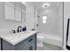 Bathroom features a blue vanity and a white tiled shower and bathtub at 3368 W Gill Pl, Denver, CO 80219