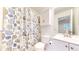 Clean and bright bathroom featuring a shower with seashell curtain, a toilet and vanity with storage at 11836 Columbine St, Thornton, CO 80233