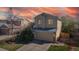 Two-story home with a two-car garage, framed by a beautiful sunset sky at 11836 Columbine St, Thornton, CO 80233