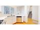 Well-lit kitchen featuring stainless steel dishwasher, white cabinets, and hardwood floors at 11836 Columbine St, Thornton, CO 80233