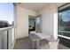 Cozy balcony seating area with city views and an open door to the living space at 55 W 12Th Ave # 211, Denver, CO 80204