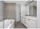 Sleek bathroom with a soaking tub, white vanity, modern fixtures, and neutral tile accents at 55 W 12Th Ave # 211, Denver, CO 80204