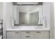 A bathroom is equipped with a large mirror, dual sinks, and a glass shower to create a modern feel at 55 W 12Th Ave # 211, Denver, CO 80204