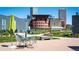 Community area with city views, outdoor seating, and manicured grass for community gatherings and relaxation at 55 W 12Th Ave # 211, Denver, CO 80204