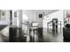 Bright dining area with modern art, dark floors, a minimalist table, and chairs near sunlit windows at 55 W 12Th Ave # 211, Denver, CO 80204